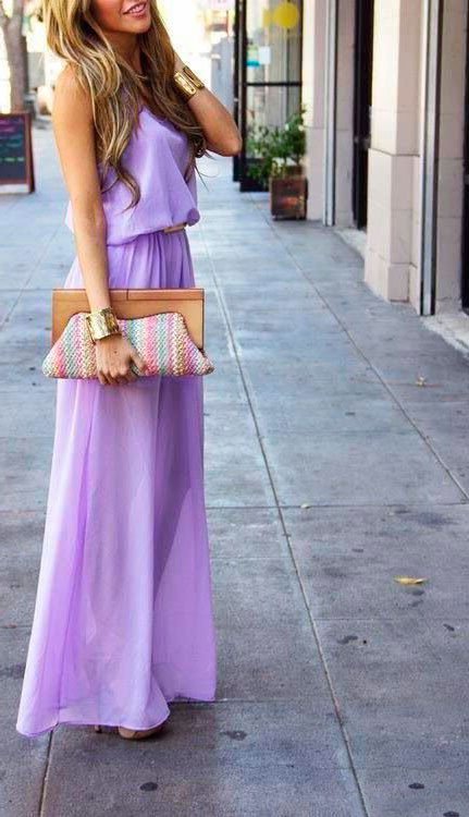 Девушка в длинном, фиолетовом платье с ремнем на поясе и клатчем
