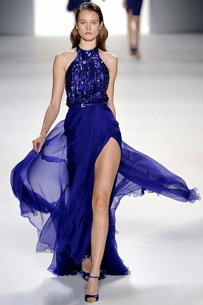 Модель в нарядном платье с пайетками, летящим подолом и глубоким разрезом