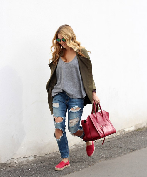 Девушка в рваных джинсах, серой футболке и красных слипонах