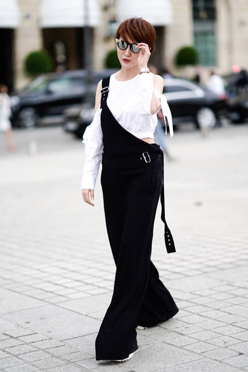 Девушка в черном широком комбинезоне и белой блузе
