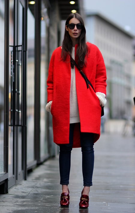 Девушка в бежевом свитере и красном пальто