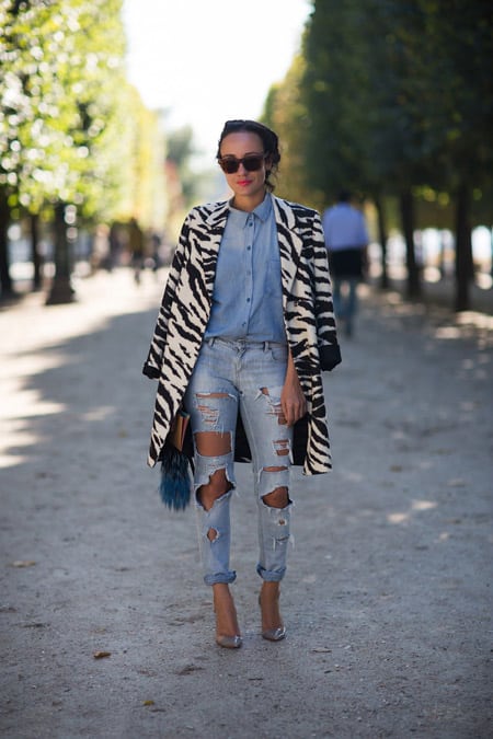 Девушка в рваных джинсах, голубой рубашке и пальто зебра