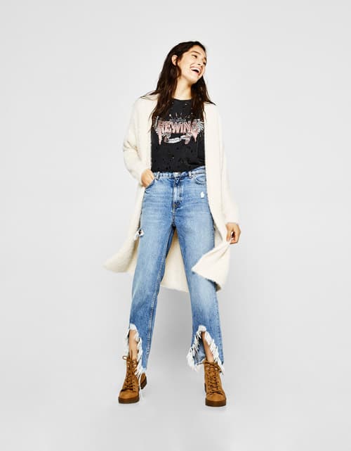 Модель bershka в рваных джинсах, футболке и кардигане