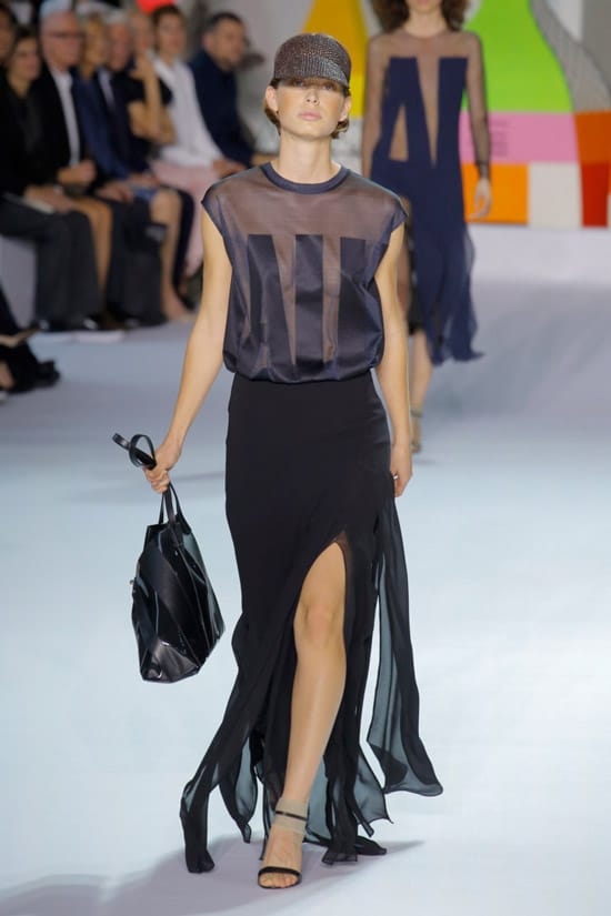 Модель в черной блузке и юбке макси с разрезом от Akris