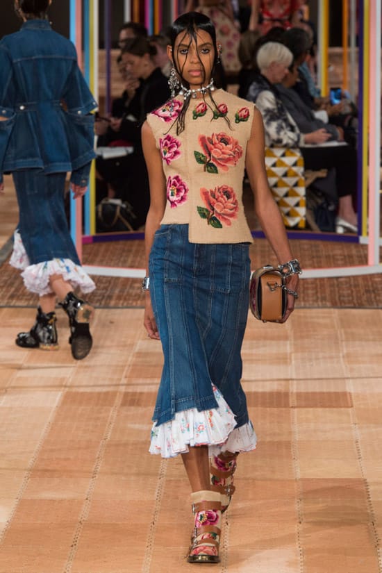 Модель в узкой джинсовой юбке и бежевый топ с цветами от Alexander McQueen