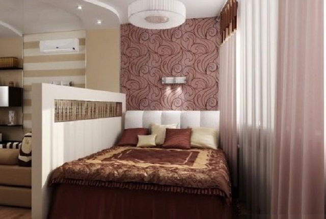 Удачное выделение спальной зоны с помощью невысокой перегородки и особенностей отделки