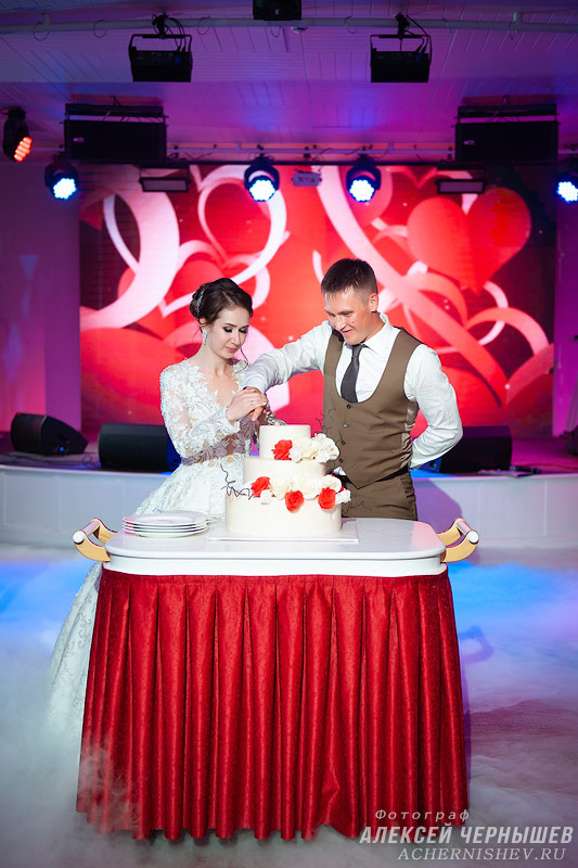 молодожены разрезают свадебный торт
